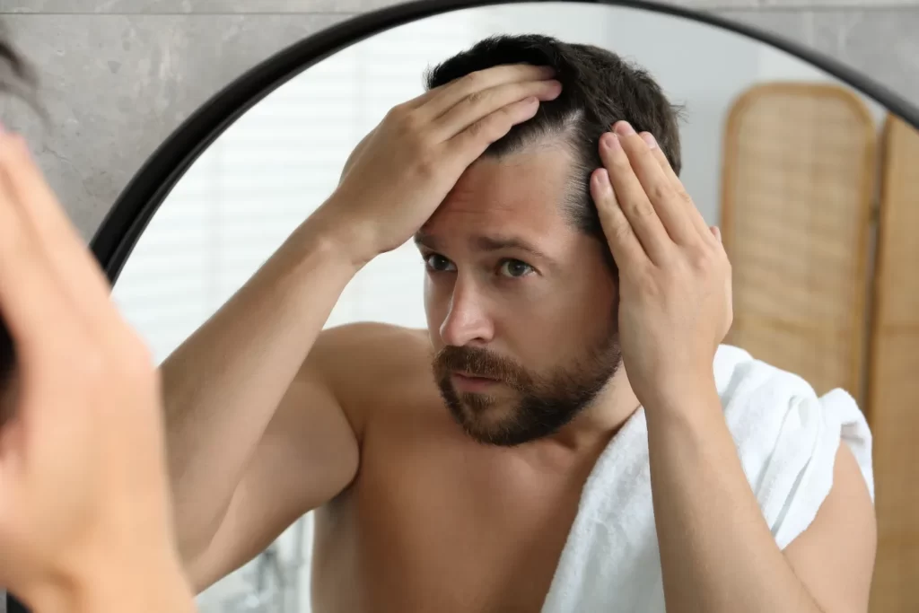 man-examining-hairline-in-mirror-at-home-2026-03-25-09-12-15-utc