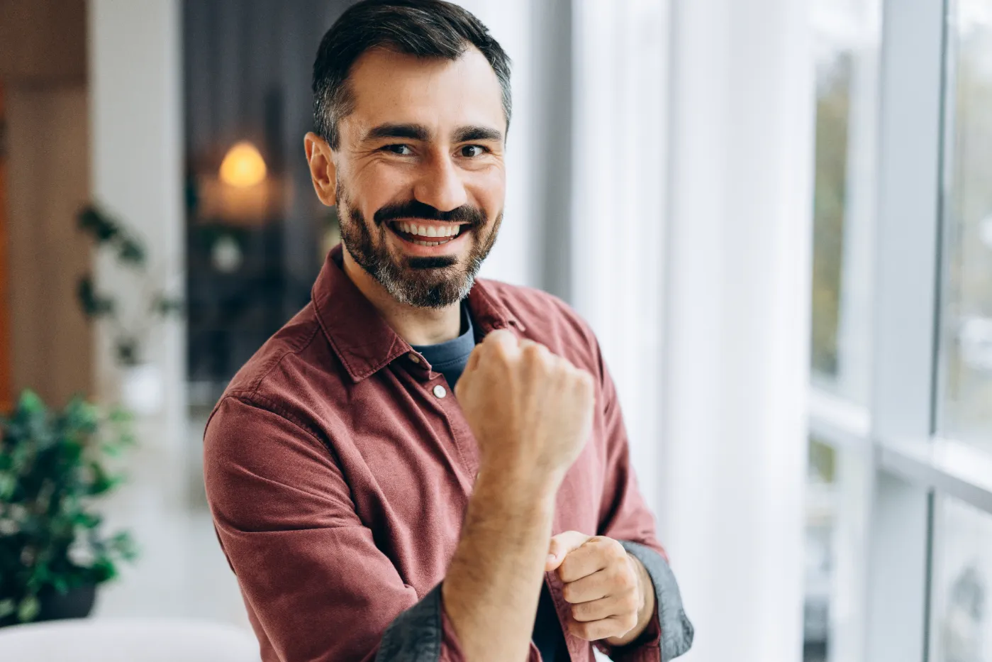 smiling-adult-man-poses-indoors-near-bright-window-2026-01-11-10-50-15-utc