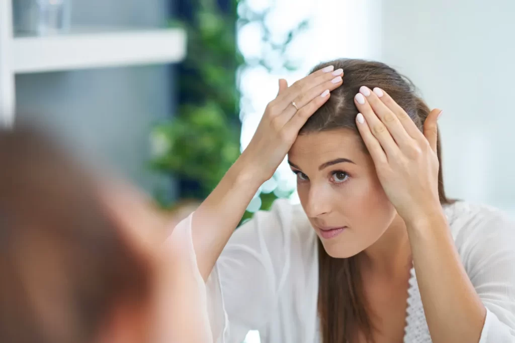 woman-checking-hair-in-bathroom-mirror-at-home-2026-03-17-20-20-46-utc